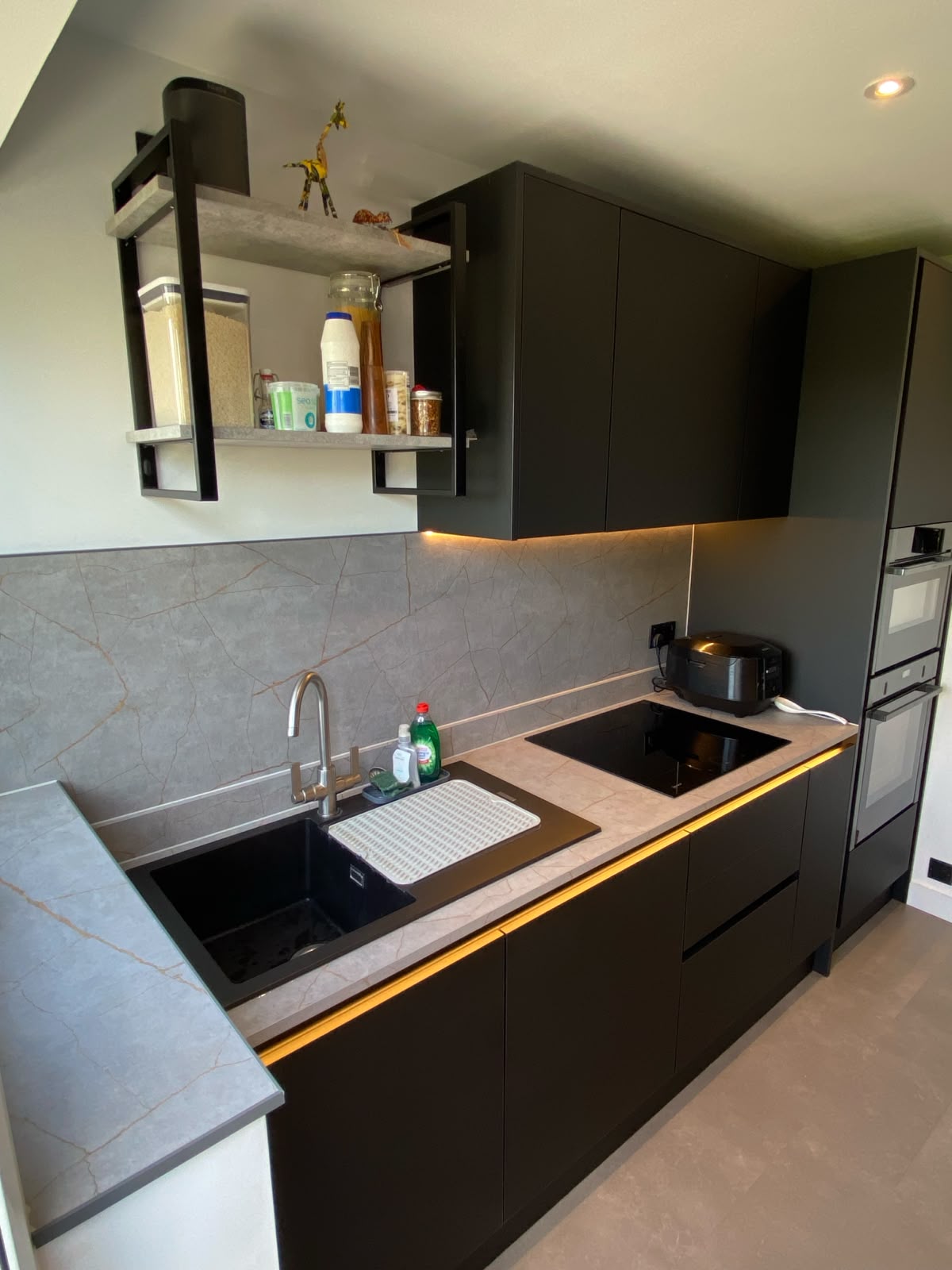 Sleek modern black kitchen with integrated appliances.